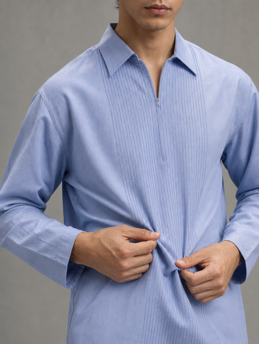 Close-up of light blue men's collared kurta showing fine vertical pin-tuck pleats and soft fabric texture.