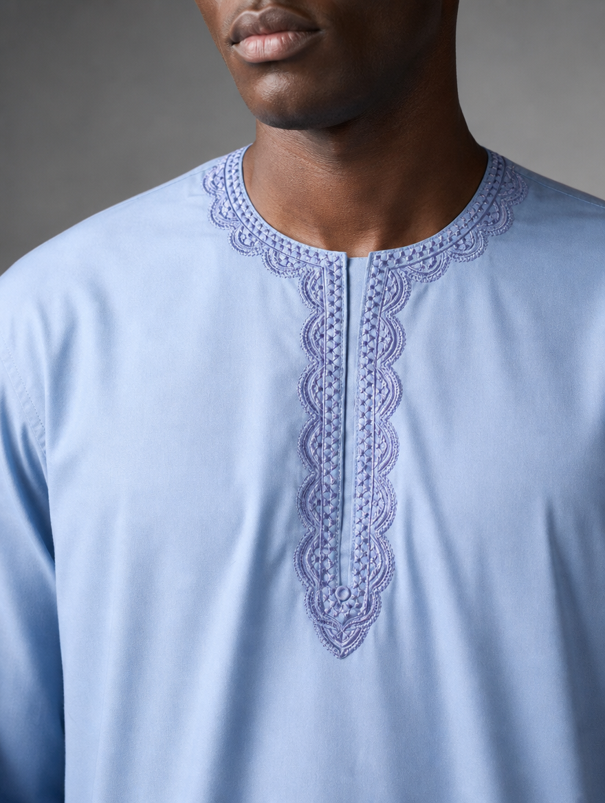 Detailed close up of light blue thread embroidery around the round neckline placket of men's short kurta.