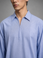 Close-up of modern spread collar and subtle front zipper placket on men's light blue pin-tucked short kurta.