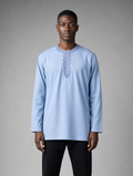 Men's light blue long sleeve short kurta with round embroidered neckline worn with black pants.