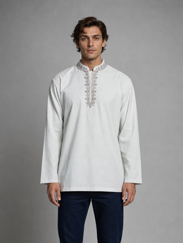 Men's light pista green long sleeve short kurta with embroidered mandarin Nehru collar worn with dark denim jeans.